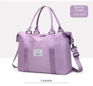 Detalle de bolsa de viaje morada impermeable con asas y correa de hombro ajustable