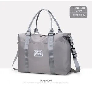 Detalle del bolso de viaje gris con asas reforzadas y hebilla de metal ajustable