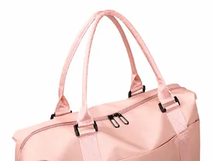 Detail van de dubbele handgrepen en stevige zwarte rits op de roze reistas voor dames