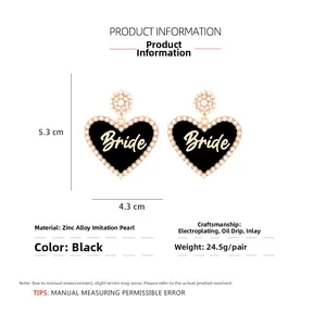 Detailed view of heart-shaped bride earrings with black oil drip and imitation pearls