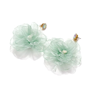 Detailed view of light green organza flower earrings with rhinestone centered studs