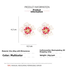 Détail de boucles d'oreilles fleur en émail avec pétales dégradés et cristaux