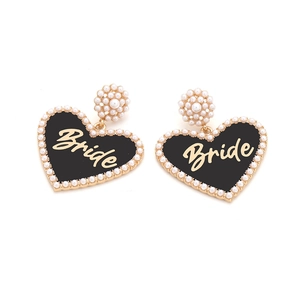 Detail of heart-shaped bride earrings with black enamel, pearls and gold finish