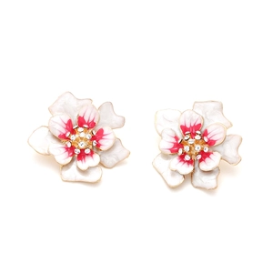 Détail de boucles d'oreilles fleurs en émail avec dégradé rose et cristaux brillants