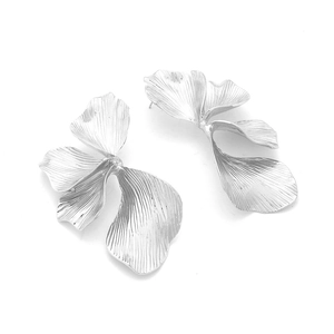 Detailed close-up of silver-tone leaf earrings featuring intricate radial brushed textures