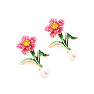 Detail of pink enamel flower earrings with green leaf and white pearl pendant drop