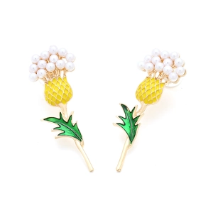 Close-up of golden thistle earrings with white pearls and vibrant green enamel leaves