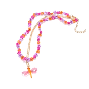 Bohemian colorful beaded flower necklace with a delicate dragonfly pendant on white background