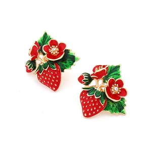 Detail of strawberry stud earrings with red enamel flower and sparkling crystal accent