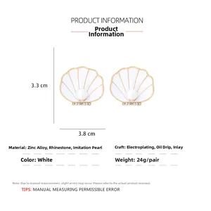 Vue détaillée des boucles d'oreilles coquillage avec émail blanc et perle d'imitation