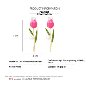 Detail view of enamel tulip earrings with pink oil dripping and faux pearl accents
