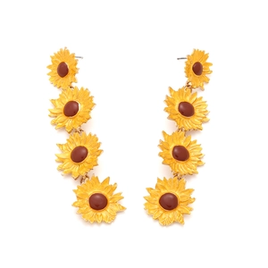 Detail of yellow sunflower drop earrings with enamel petals and tiered floral design