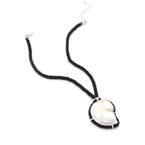 Détail macro du pendentif en coquillage naturel sur cordon noir avec fermoir en argent