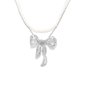 Double-layer necklace with white pearls, silver chain, and textured metal bow pendant