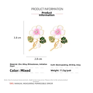 Detail view of enamel flower earrings with gradient petals, rhinestones and faux pearls