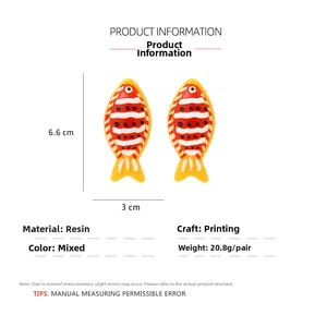 Macro view of colorful resin tropical fish earrings with product dimensions and weight