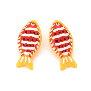 Macro detail of tropical clownfish earrings with bright yellow and red glossy finish