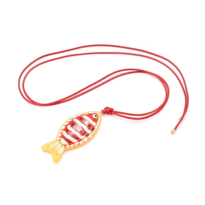 Close-up of handmade tropical fish pendant with red braided rope and fine texture