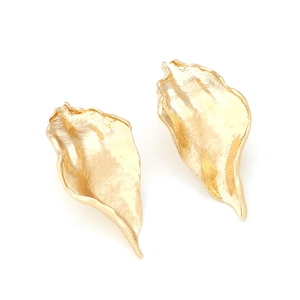 Macro detail of golden leaf earrings showing irregular organic shapes and hammered metal texture