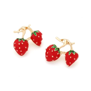 Macro detail of red enamel strawberry earrings with gold accents and green leaves