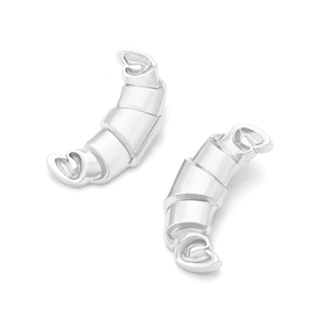 Détail macro de boucles d'oreilles croissant argentées au design de spirale