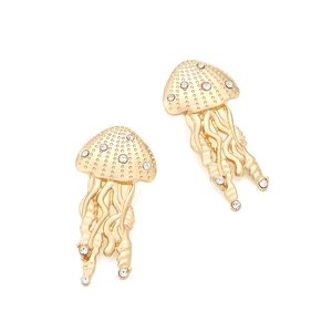 Golden jellyfish dangle earrings with rhinestones in a minimalist studio setting