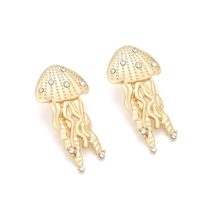 Macro detail of golden jellyfish earrings featuring sparkling rhinestones and metal textures