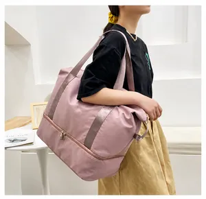 Pink travel bag detail showing the bottom zipper compartment for shoes or wet items