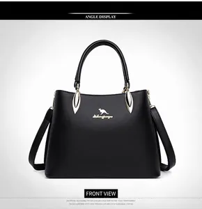 Close-up of black leather tote bag featuring gold kangaroo logo and metallic hardware