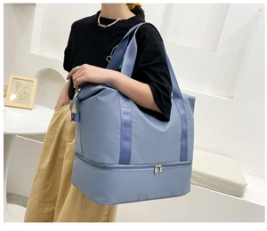 Detalle de la bolsa de viaje azul con separación para seco y mojado en un modelo