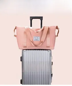 Detailed view of pink waterproof fitness bag placed on a silver suitcase for travel
