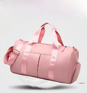 Detailed view of pink waterproof travel bag featuring lightweight fabric and reinforced handles