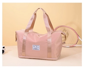 Close-up of pink Oxford cloth gym bag featuring waterproof fabric and woven brand label
