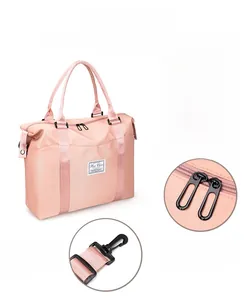 Detail view of pink nylon travel bag featuring dual metal zippers and detachable hooks