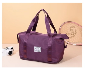 Detail of purple oxford travel bag showing bottom shoe compartment and brand label