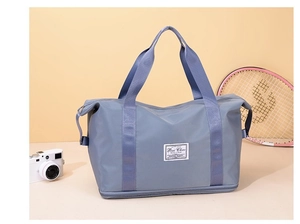 Detail view of the deep blue travel bag showing durable waterproof fabric and carry handles