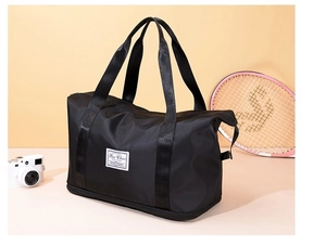 Detail of expandable black travel bag showing dry-wet separation pocket and durable fabric