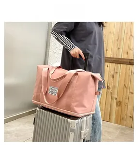 Pink oxford fabric travel bag with trolley sleeve mounted on suitcase handle
