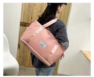 Pink travel bag detail featuring expandable base compartment for shoe storage and wet separation