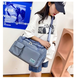 Dettaglio laterale della borsa fitness blu grigio con multi-tasche e texture in nylon
