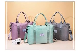 Three colors of nylon travel bags with shoulder straps on a warm yellow background