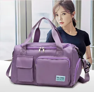 Dettaglio della borsa sportiva viola fissata al manico del trolley da viaggio