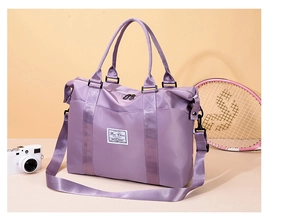 Detail of purple nylon travel bag with adjustable strap and front brand patch
