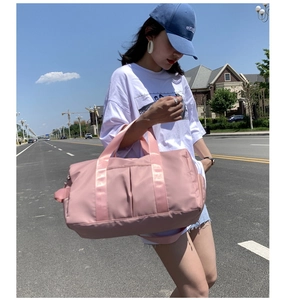 Pink large capacity waterproof travel bag for sports and fitness shown on shoulder
