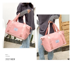 Pink waterproof travel bag showing size scale and carrying style in an outdoor setting