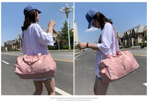 Detail of light pink waterproof travel bag with reinforced straps and side zipper pocket