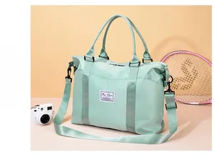 Detail of mint green travel bag with adjustable strap and durable nylon material