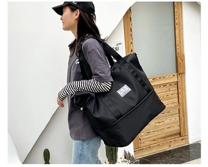 Detail of expandable black oxford travel bag featuring a bottom wet-dry separation pocket