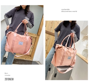 Pink nylon travel bag with dry wet separation and adjustable shoulder strap detail