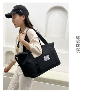 Detail of black oxford fitness bag with widened handles and waterproof compartment